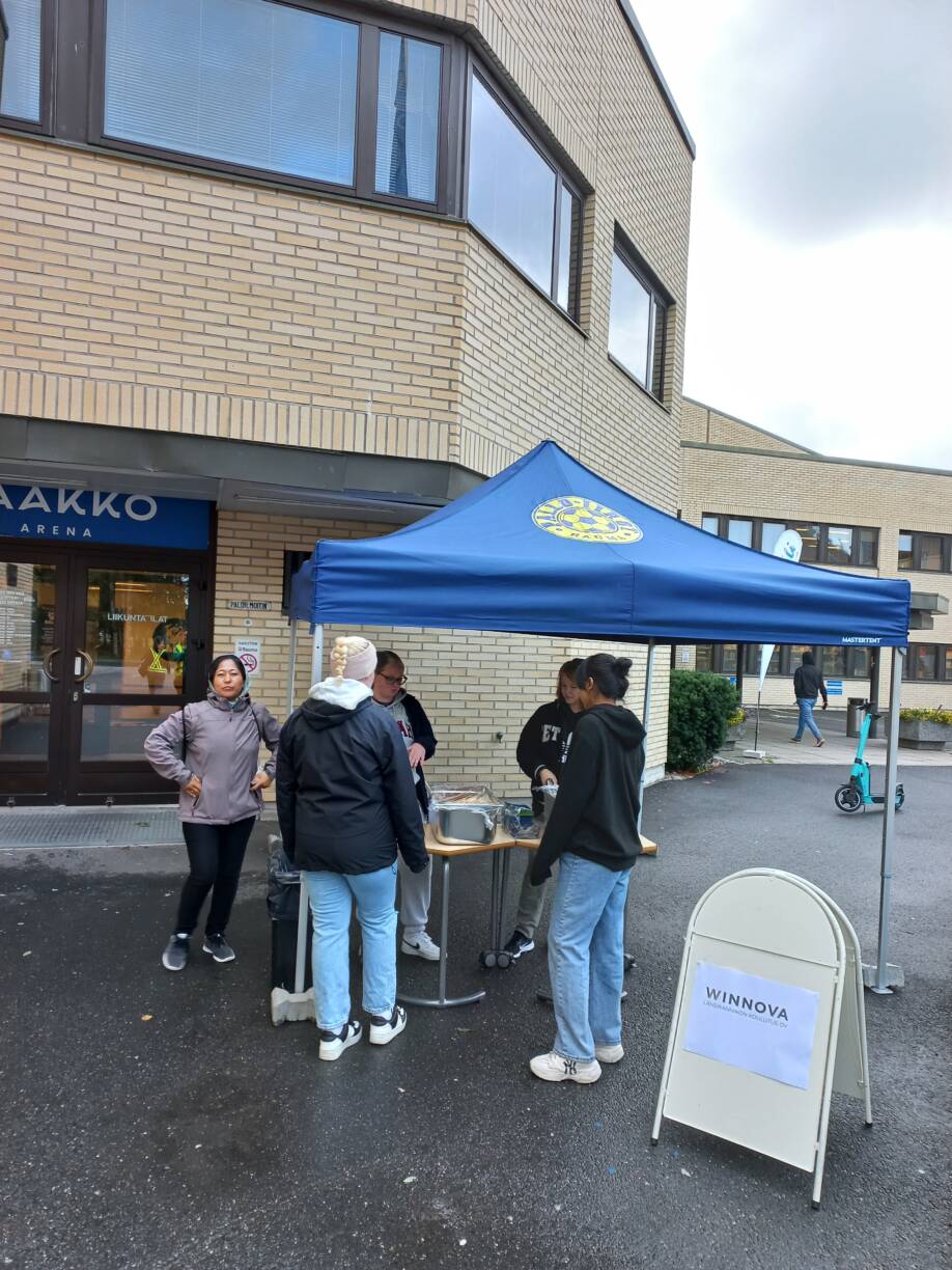 Elintarvikealan opiskelijat jakavat hedelmäpaloja ulkona.