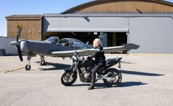 WinNovan vuoden 2024 opiskelija Heidi Hellsten moottoripyörän päällä lentokonehallin edessä.