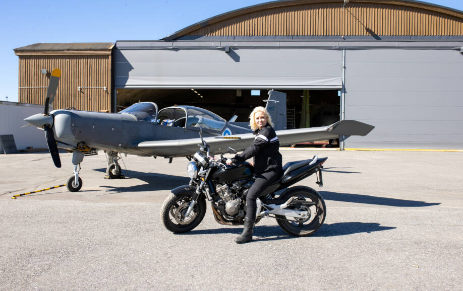 WinNovan vuoden 2024 opiskelija Heidi Hellsten moottoripyörän päällä lentokonehallin edessä.