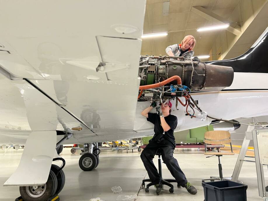 Heidi Hellsten lentokonehallissa korjaa lentokonetta.