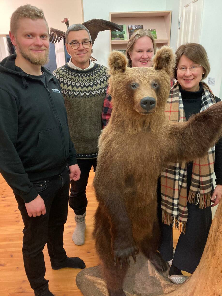 Matkaan osallistuneet  poseeraavat täytetyn Seppo-karhun ympärillä.