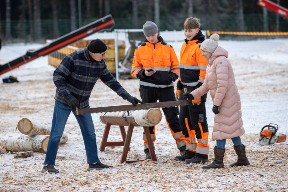 Justerikisapaikalla pariskunta sahaa puuta.